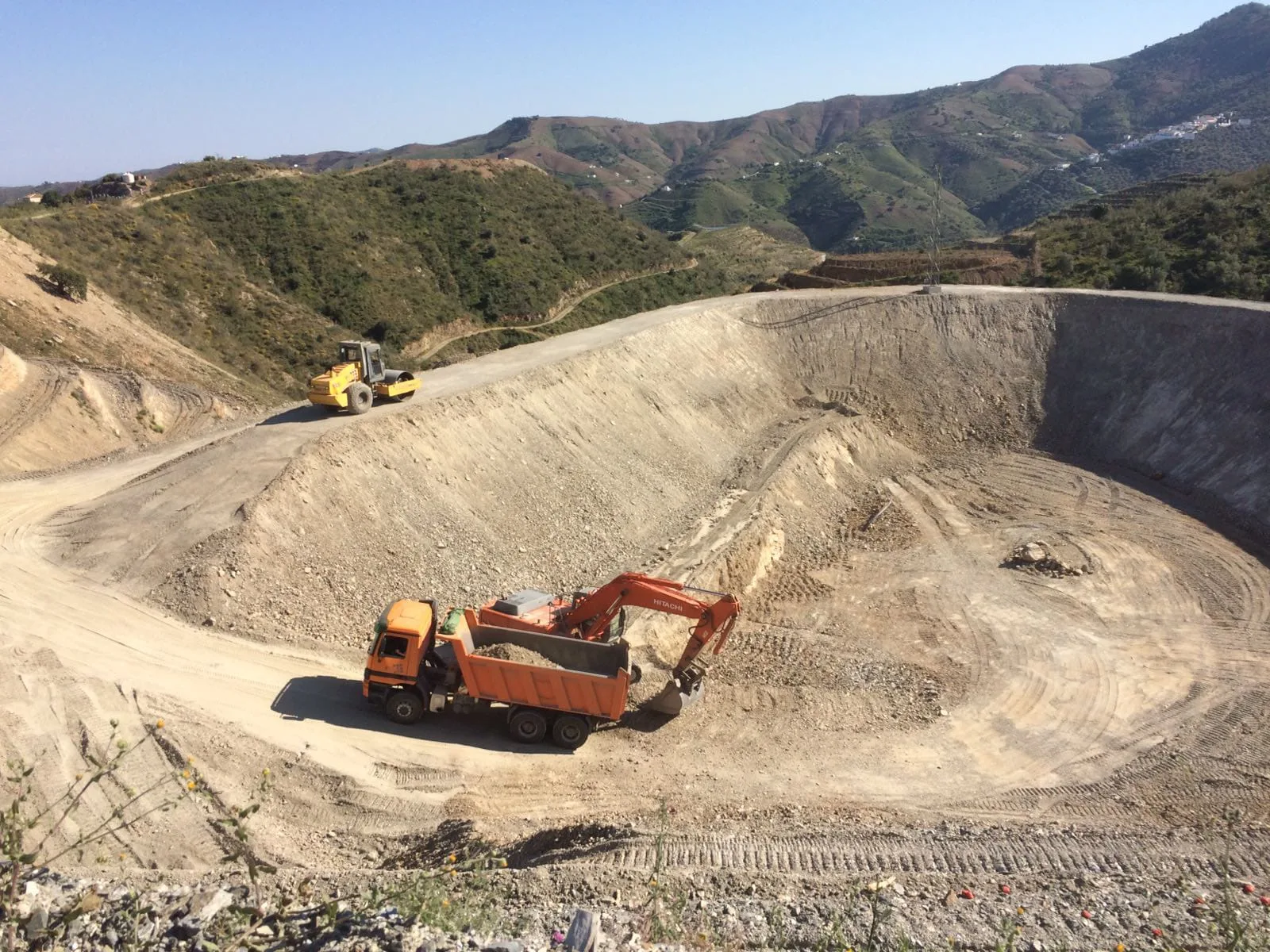 Gran excavación para balsa de riego en ladera de montaña en Málaga, con camión y excavadora ECTRO trabajando en Andalucía