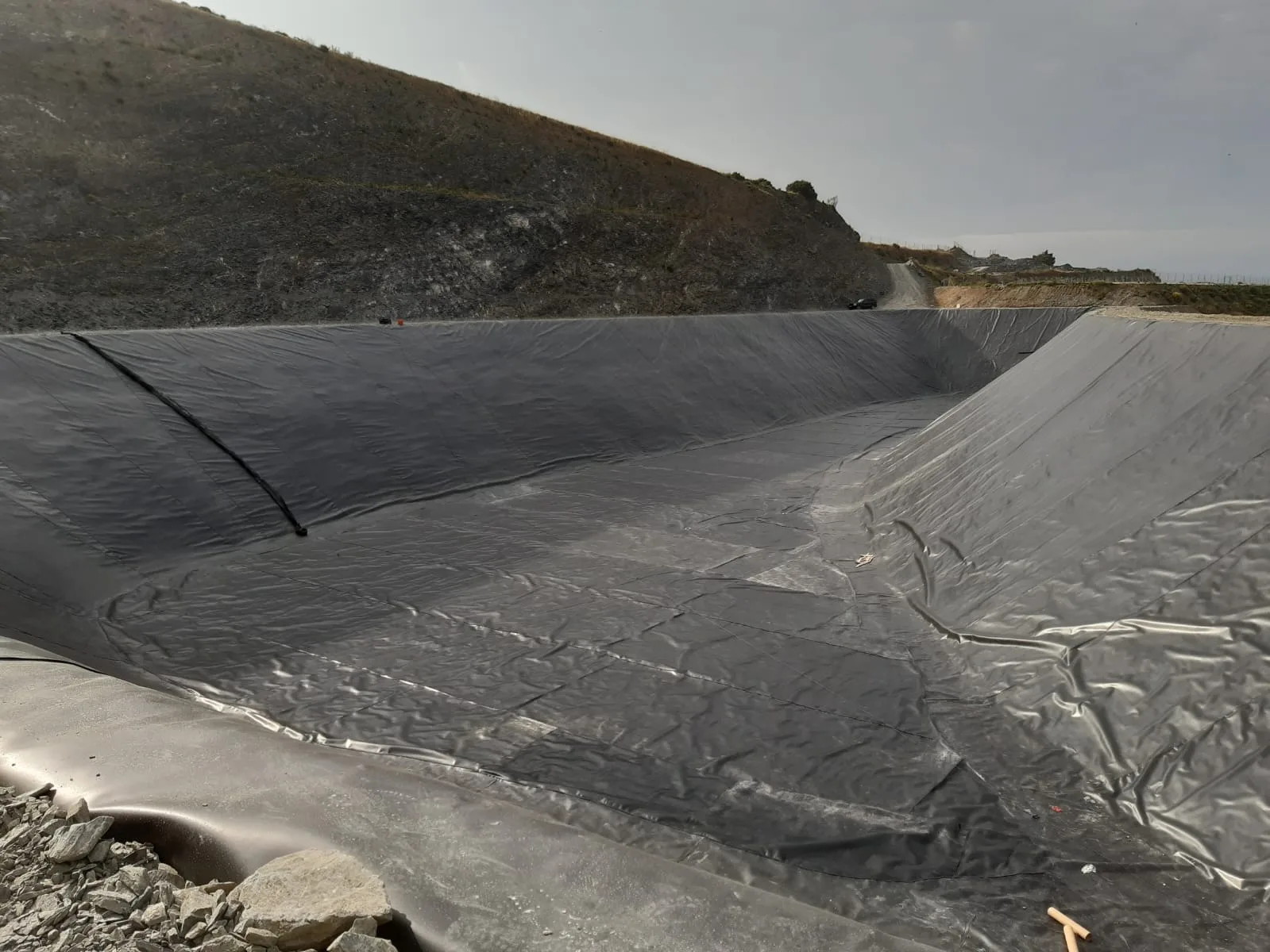 Geomembrana HDPE extendida en taludes de balsa de riego