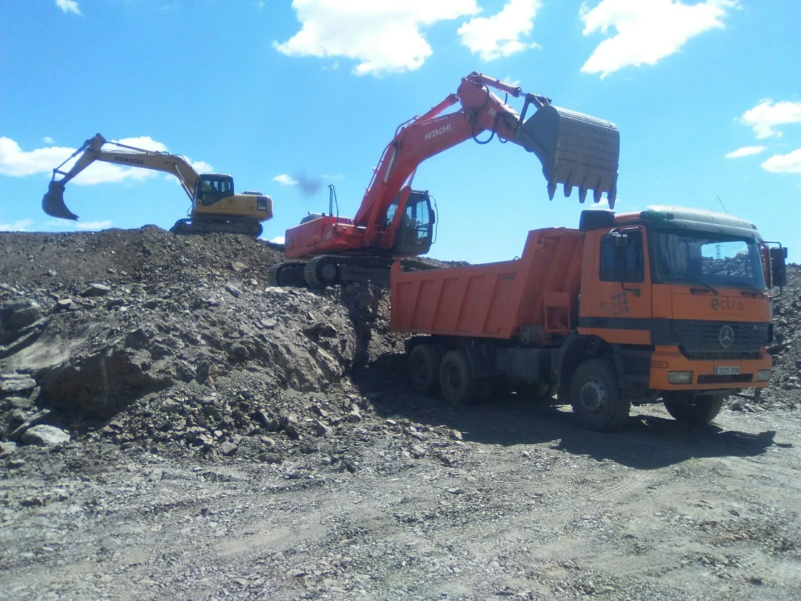 Excavadora y camión bañera en obra de movimiento de tierras en Granada