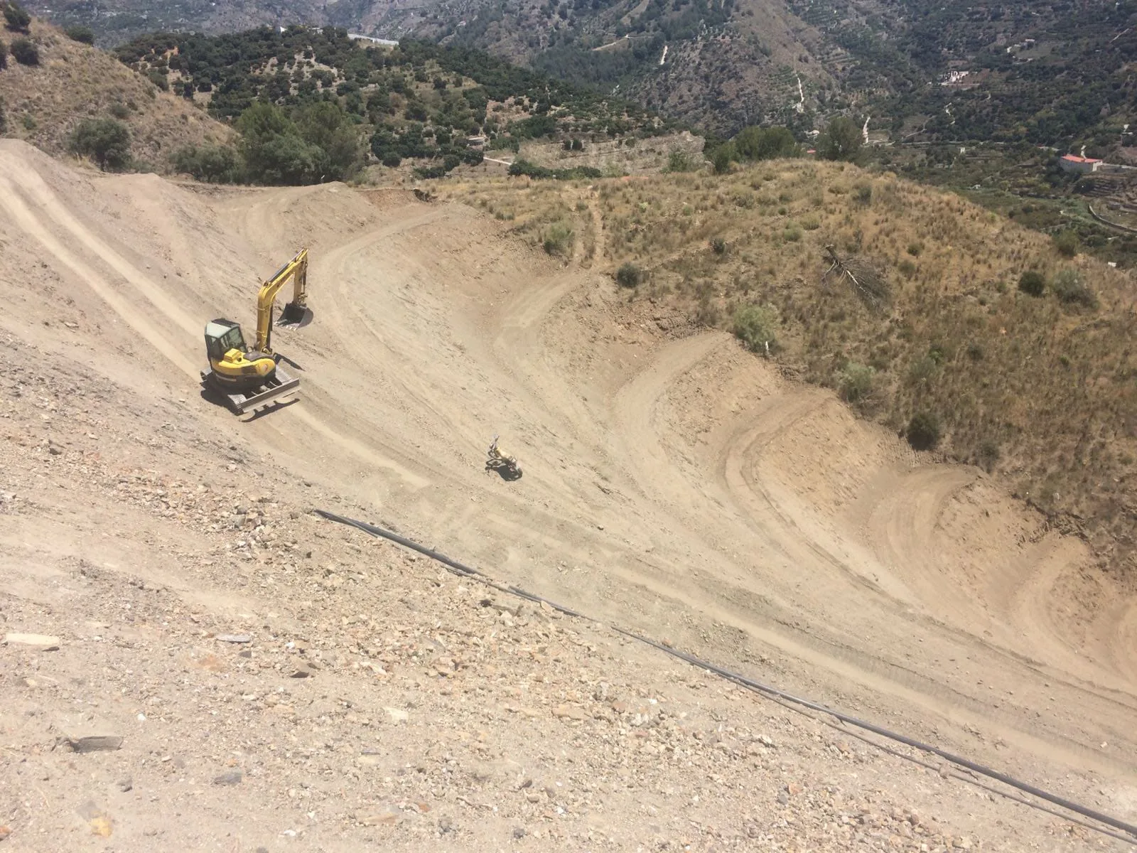 Excavadora trabajando en ladera para transformación de finca agrícola